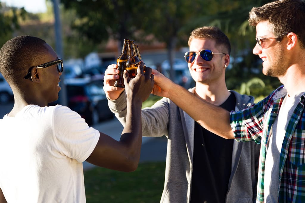 Portrait of group of friends enjoying with beer, toasting and laughing.